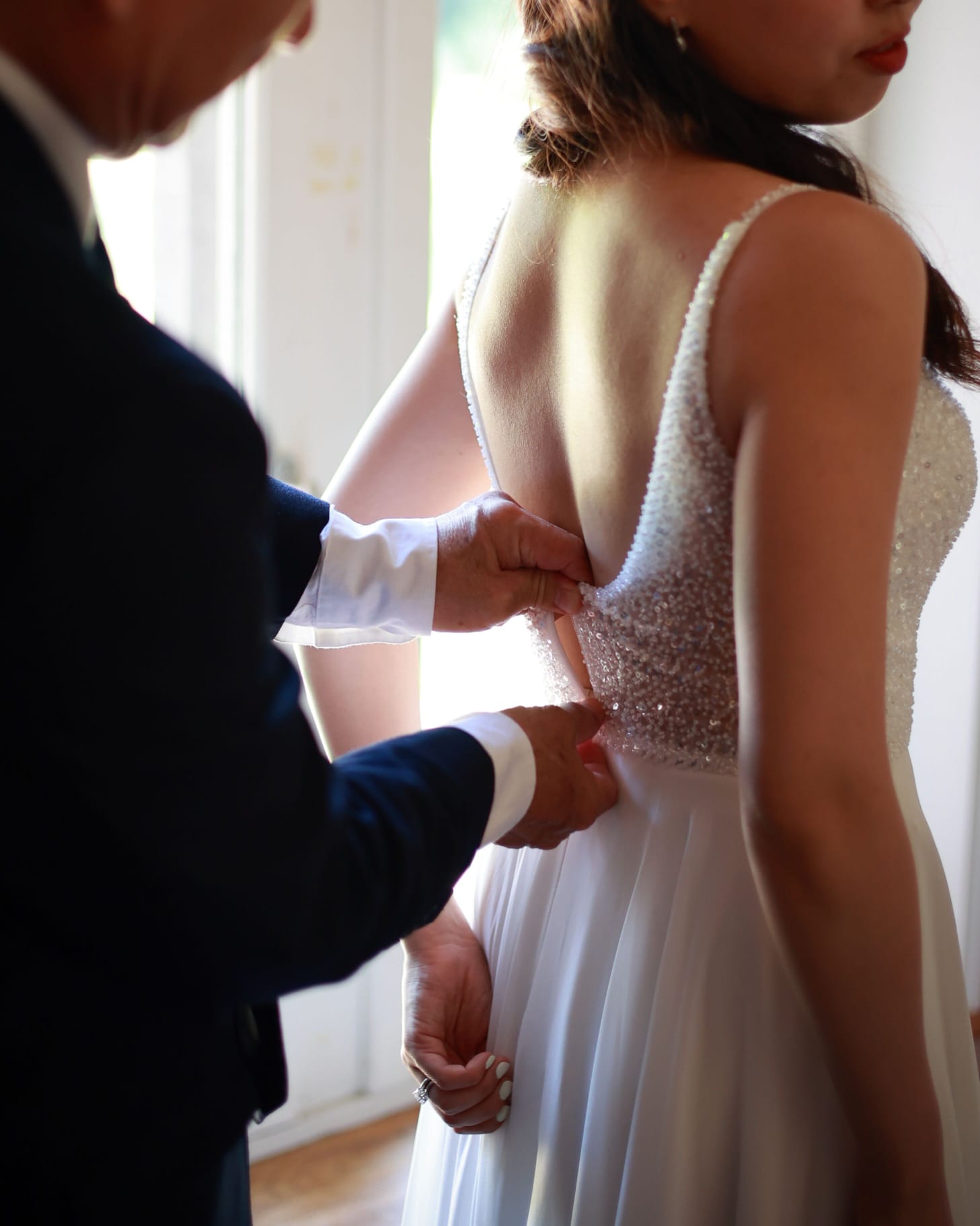 Instant d'habillage : le père aide sa fille à fermer sa robe